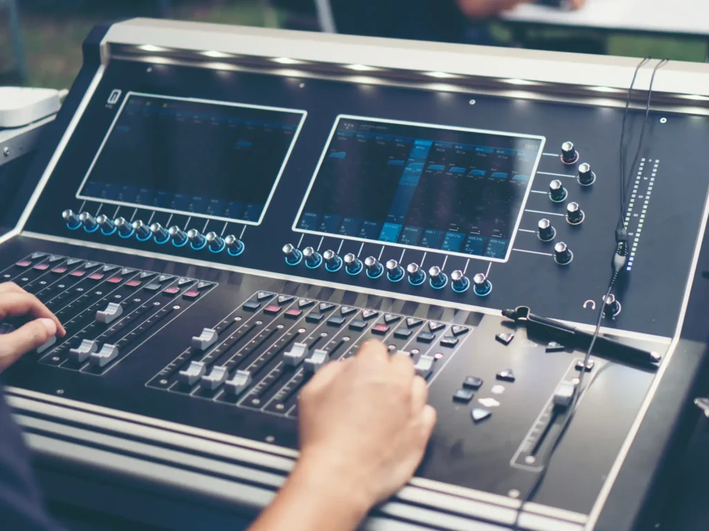 Digitale Tonmischkonsole mit zwei Displays und Fadern während der Bedienung – professionelle Veranstaltungstechnik in Kirchheim bei München