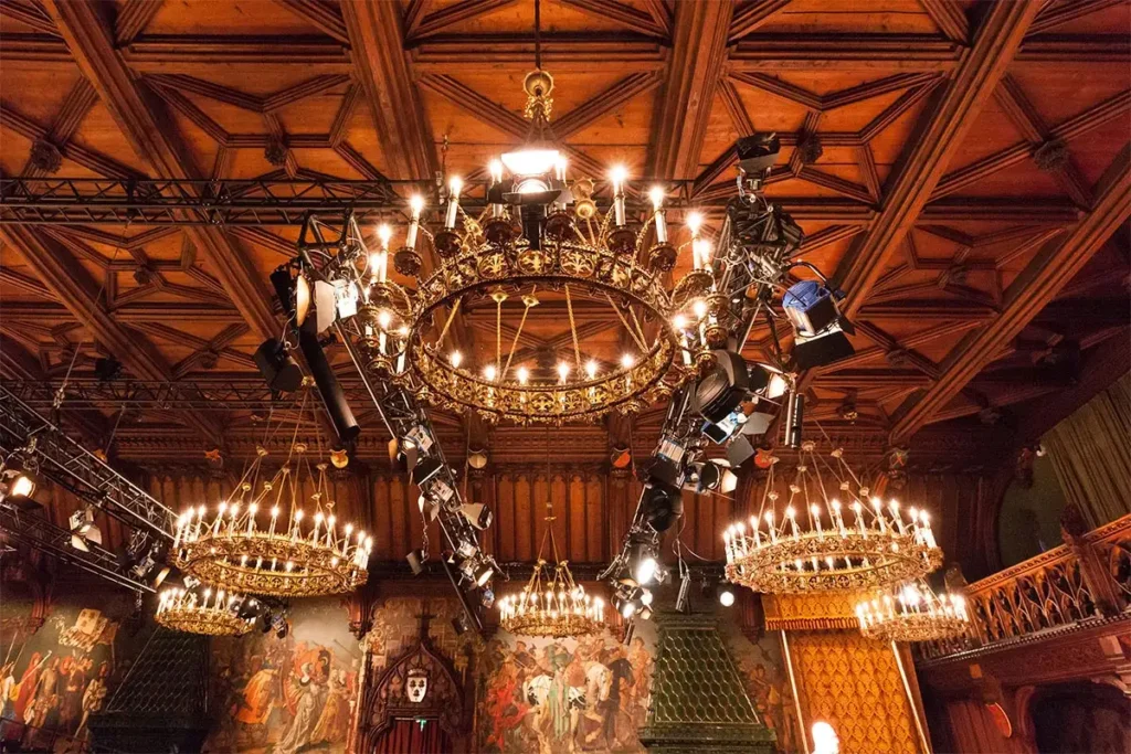 Mehrere Luster bzw. riesige Leuchten, die von der Decke hängen und auf der Decke hängen diverse Geräte, Beleuchtungen, usw. von Orange Veranstaltungstechnik in Penzberg für ein Event