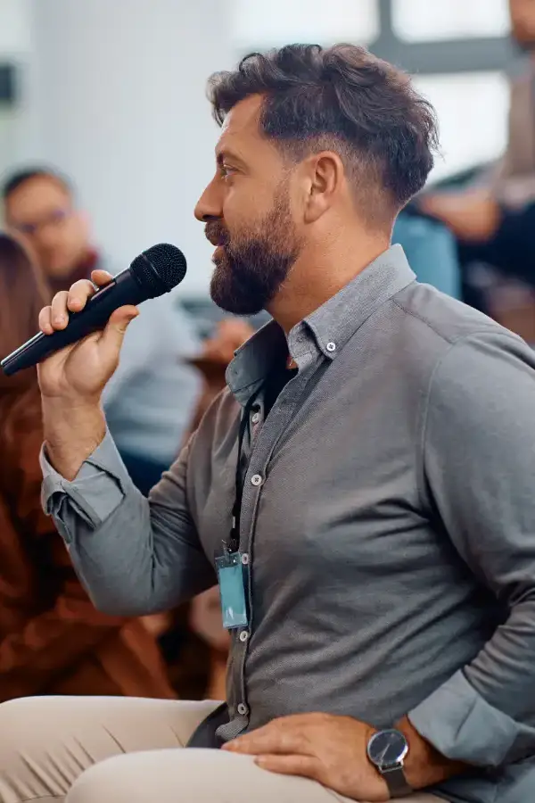 Keynotespeaker eines Firmenempfangs spricht in ein Mikrofon