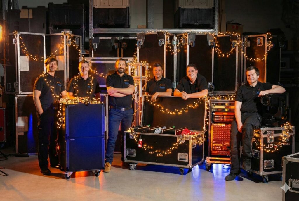 Das Team von Orangeveranstaltungstechnik steht hinter Flightcases und mit Lichterketten geschmückt