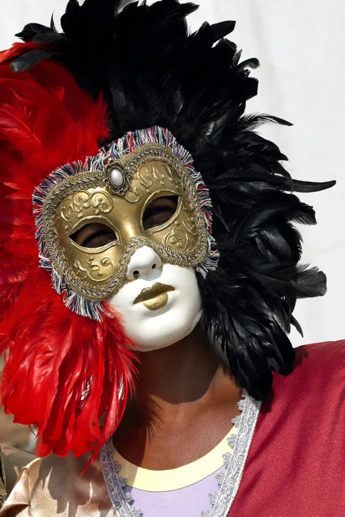 weiße Karnevalsmaske mit rot & schwarzen Federschmuck